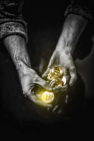 Bitcoin in man's hand, closeup. Cryptocurrency investment concept.の写真素材
