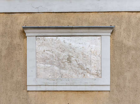 Horizontal closeup of square empty signboard on a building with classic architecture