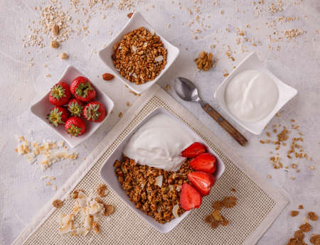 Bowl of homemade granola with yogurt and fresh strawberries 