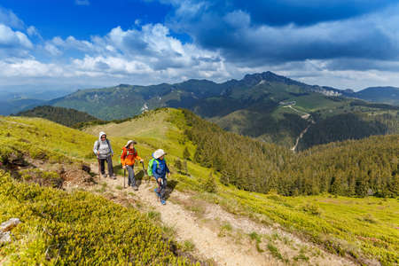 Woman with her children hiking in the mountainの写真素材