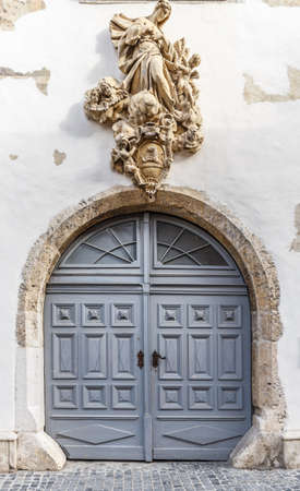 Vintage wooden entry door decorated with carved sculptures