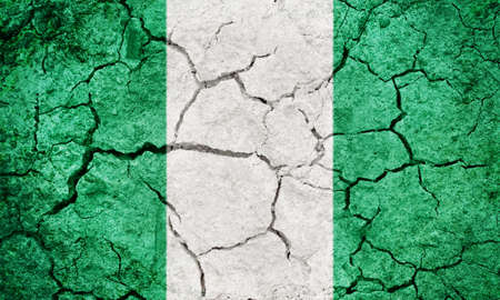 Federal Republic of Nigeria flag on dry earth ground texture backgroundの写真素材