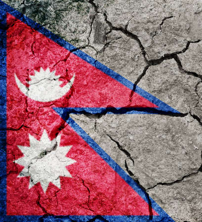 Federal Democratic Republic of Nepal flag on dry earth ground texture backgroundの写真素材