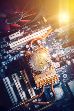 The gold coin of digital crypto currency Bitcoin lies on the motherboard of the computerの写真素材