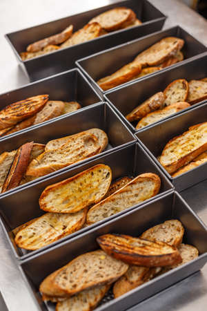 Slices of rosted bread with olive oil and garlic in pan ready to serveの写真素材