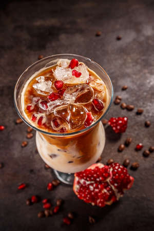 Iced coffee with milk in tall glass flavored with pomegranate syrupの写真素材