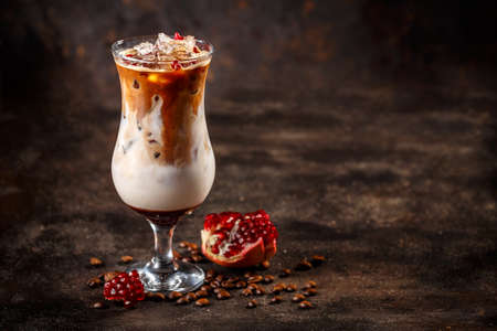 Iced coffee latte with pomegranate syrup, space for your textの写真素材
