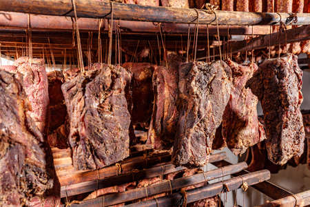 Smoked pork chop factory large amounts made at once on hooks in meat smoking chamberの写真素材