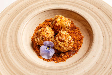 Cottage cheese dumpling rolled in roasted almond, carob powder with hot honeyの写真素材