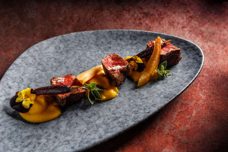 Deer sirloin with mashed sweet potatoes, blanched purple carrots, wine jam with quinceの写真素材