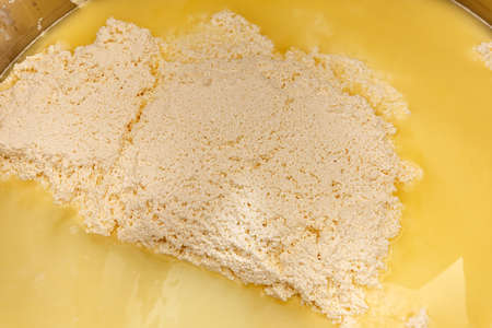 Freshly fermented cheese being moved on during production processの写真素材