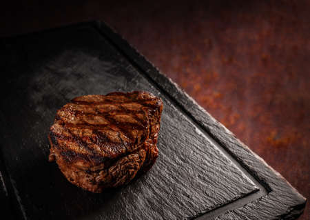Matured Argentinian ribeye steak on black slate boardの写真素材