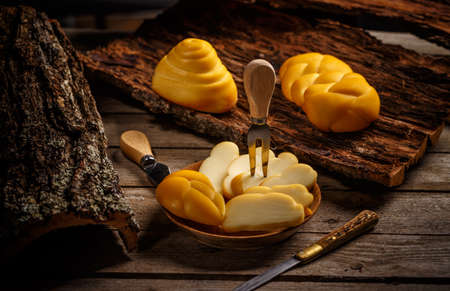 Variety of smoked braided cheese on rustic wooden backgroundの写真素材