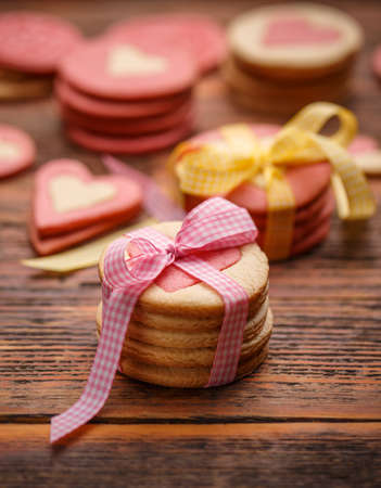 Cookies for Valentine's Day with pink ribbon on wooden tableの写真素材