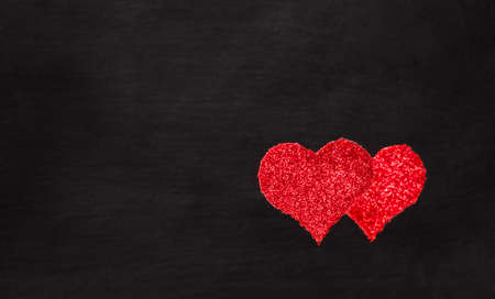 Glittering red hearts on black background, space for your textの写真素材
