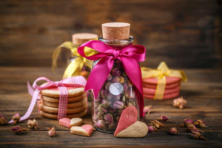 Rose buds tea in glass jar and heart shaped cookiesの写真素材