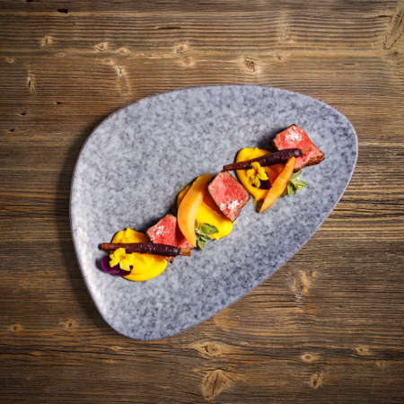 Flat lay of deer sirloin with mashed sweet potatoes on wooden backgroundの写真素材