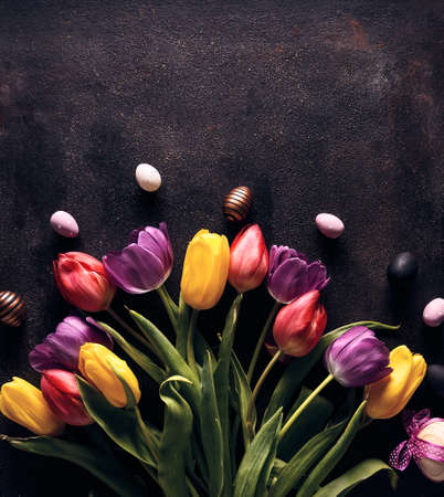 Easter holiday background with Easter eggs and tulip flowers. Top view and copy spaceの写真素材