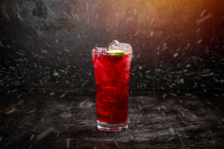 Cranberry beverage with ice and lime on dark backgroundの写真素材