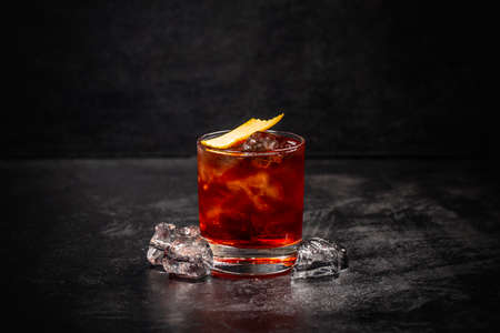 Glass of Negroni cocktail decorated with orange peel on dark backgroundの写真素材
