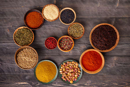 Variety of spices and herbs on wooden tableの写真素材