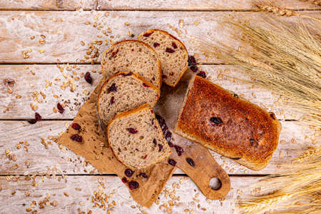 Flat lay of cranberry loaf of bread on wooden background
