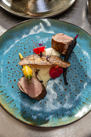 Pork tenderloin with mashed potatoes grilled baby carrots and sweet potato chipsの写真素材