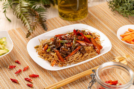 Slices of beef in spicy brown sauce with noodles and vegetables, Chinese main courseの写真素材