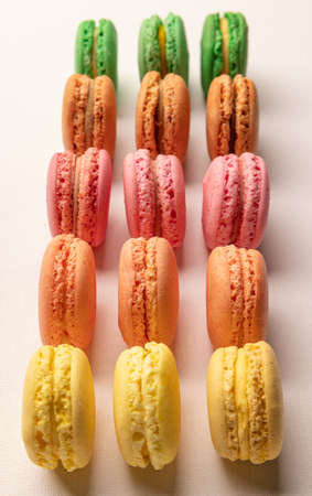 Colorful cake macaroons in row on a light background