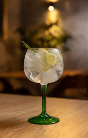 Cold refreshing tonic water with ice decorated with rosemary and lemonの写真素材