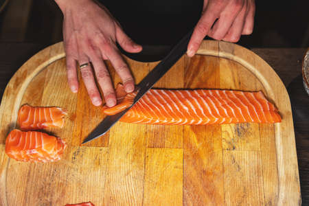 Chef hands slicing fresh fishの写真素材