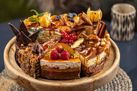 Different slices of various cakes, making a single whole torte on the cake standの写真素材