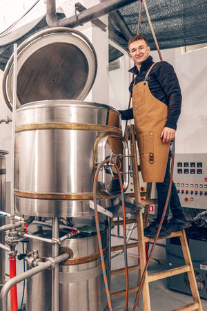 Man is working at craft beer factory. Production of craft beer.