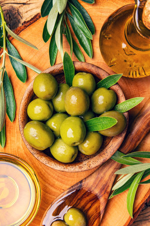Wooden bowl with green olives, still life concept, top viewの写真素材