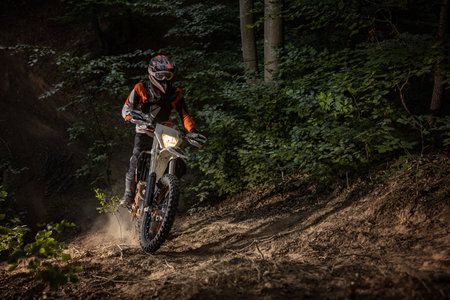 Motocross racer riding on forest. Extreme sport concept