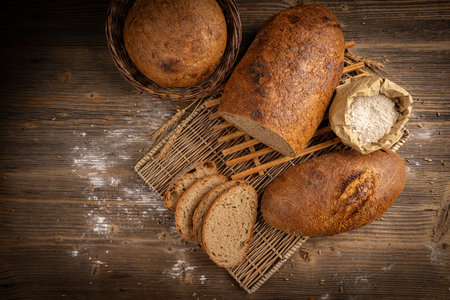 Fresh bread on wooden background. Whole and sliced loaves and breads, top viewの写真素材