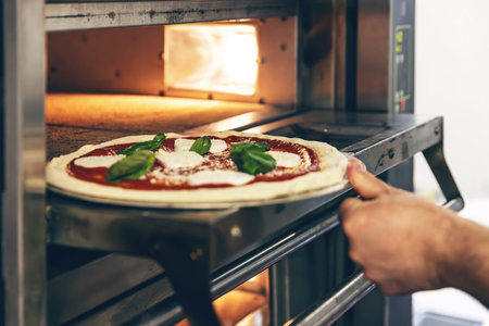 Fresh pizza placed in oven for baking