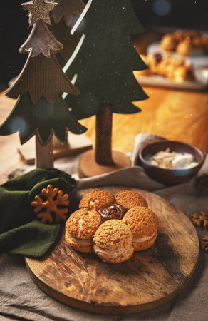Cream puffs arranged in flower shape on wooden board, offering sweet and visually appealing treatの写真素材