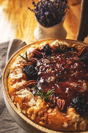 Delicious fig and rosemary tart with pecan nuts, almond flakes and rosemary enjoying a cozy atmosphereの写真素材