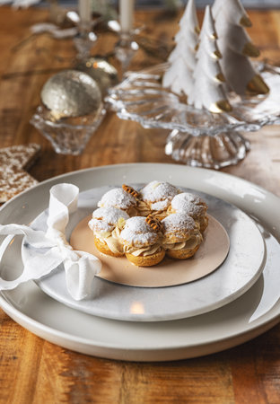 Delicious paris brest pastry sprinkled with icing sugar on Christmas table settingの写真素材