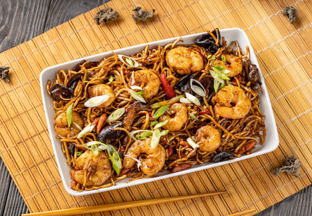 Top view of shrimp and vegetable noodles garnished with chopped green onionsの写真素材