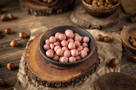 Crunchy roasted hazelnuts coated with strawberry flavour white chocolate