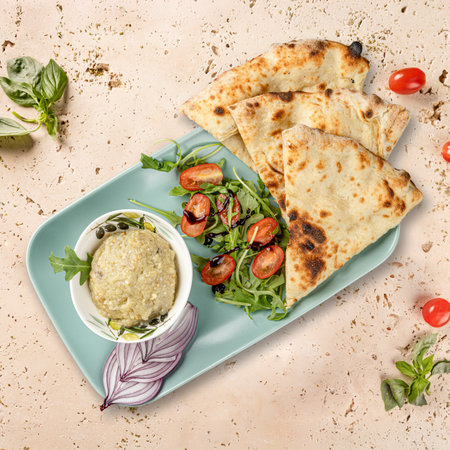 Baba ghanoush, pita bread, and a fresh salad are served together, creating a vibrant and appetizing mealの写真素材