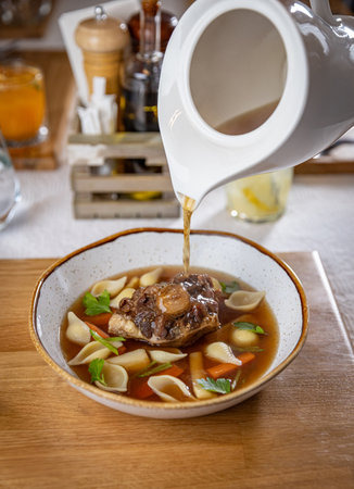 Oxtail soup being served in a restaurant, showcasing culinary expertise and a delicious mealの写真素材