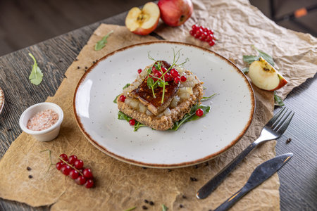 Gourmet appetizer featuring pan fried foie gras on toast with apple and red currantsの写真素材