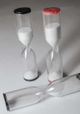 three hourglasses, two running an one fallenの写真素材