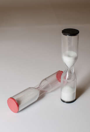 two hourglasses black one running red one fallen