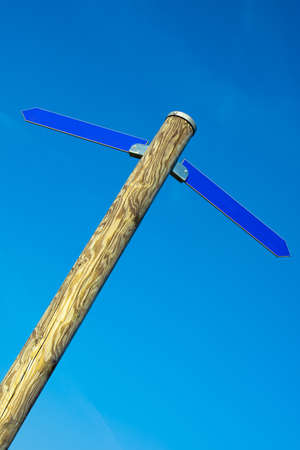 Wooden pole with two blue direction arrows