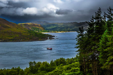 Scenic Sunlit Coast With Ferry Boat On The Isle Of Skye In Scotlandの写真素材
