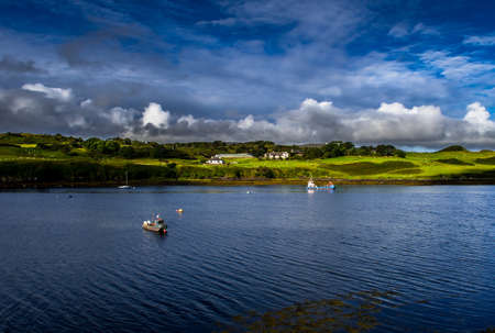 Picturesque Settlement And Small Boats In Harbor Of Dunvegan At The Coast Of The Isle Of Skye In Scotlandの写真素材